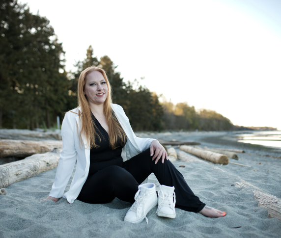 woman sitting in sand, on a beach